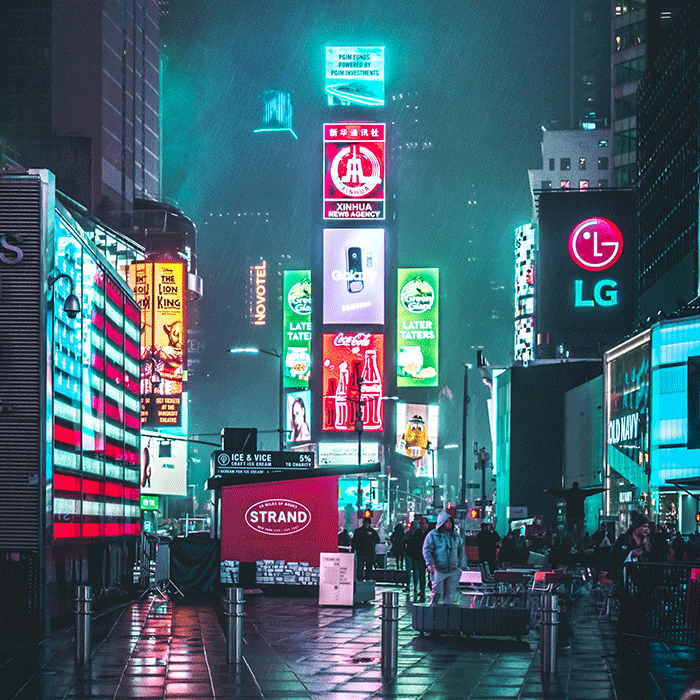 Rainy nighttime picture of a city with many electric billboards